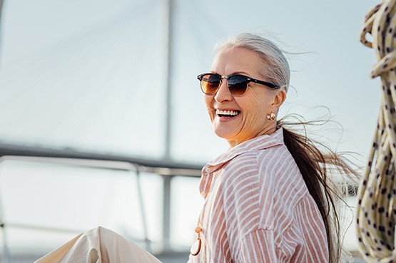 Smiling woman relaxing on boat with sunglasses