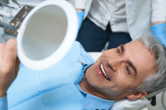 A patient admiring his dental implants