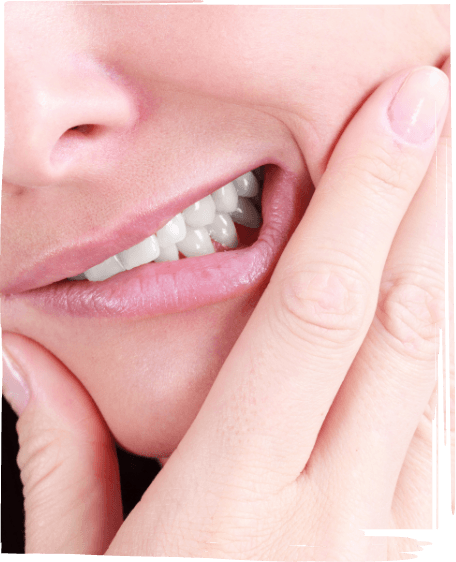 Close up of person wincing and holding their cheek in pain before tooth extractions